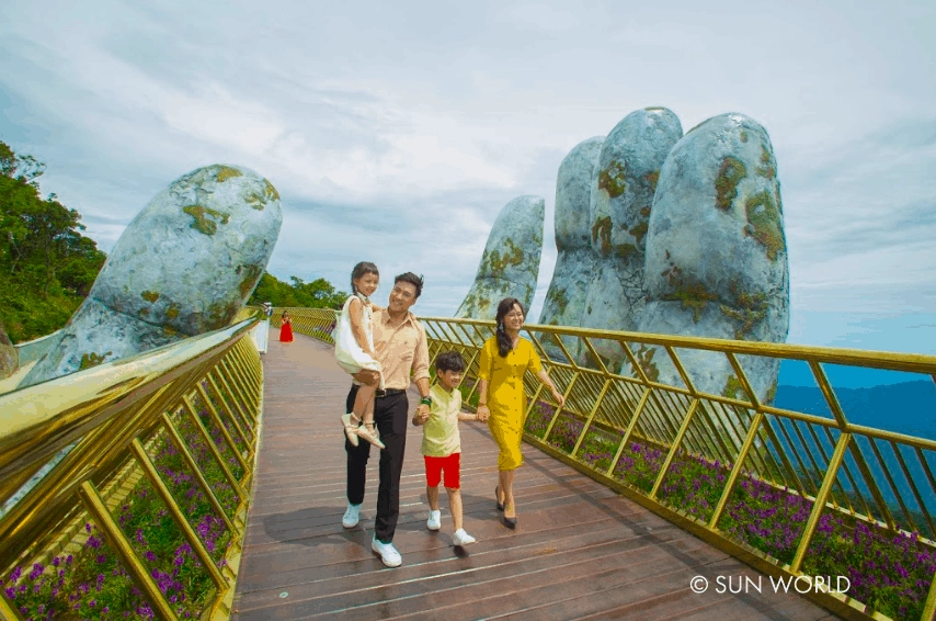 Cầu Vàng được làm từ thép tấm sơn nhũ vàng sáng bóng, 2 bên cầu là hoa cúc Nữ hoàng xanh Lobelia